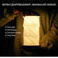 White collapsible lantern lamp with geometric origami-style fold pattern illuminated in warm light
