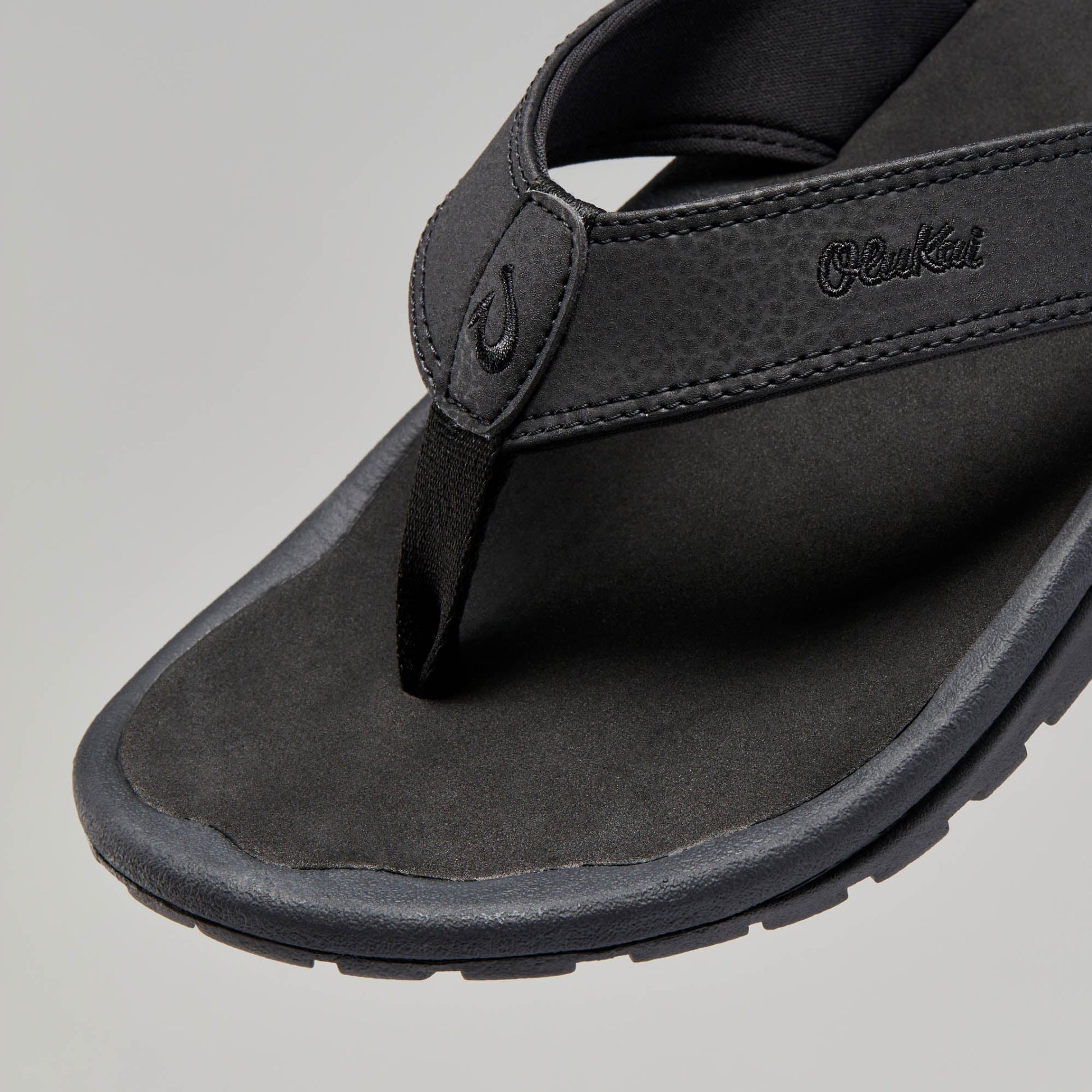 OluKai Men's Ohana black leather flip flop sandal with toe post and cushioned footbed