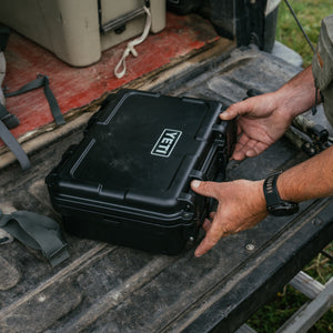 YETI Loadout GoBox 10 black hard case being handled on truck tailgate outdoors