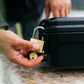YETI GoBox 10 in black being secured with a brass padlock and key outdoors