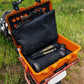YETI Loadout GoBox orange protective case open on motorcycle showing black interior inserts and optics gear
