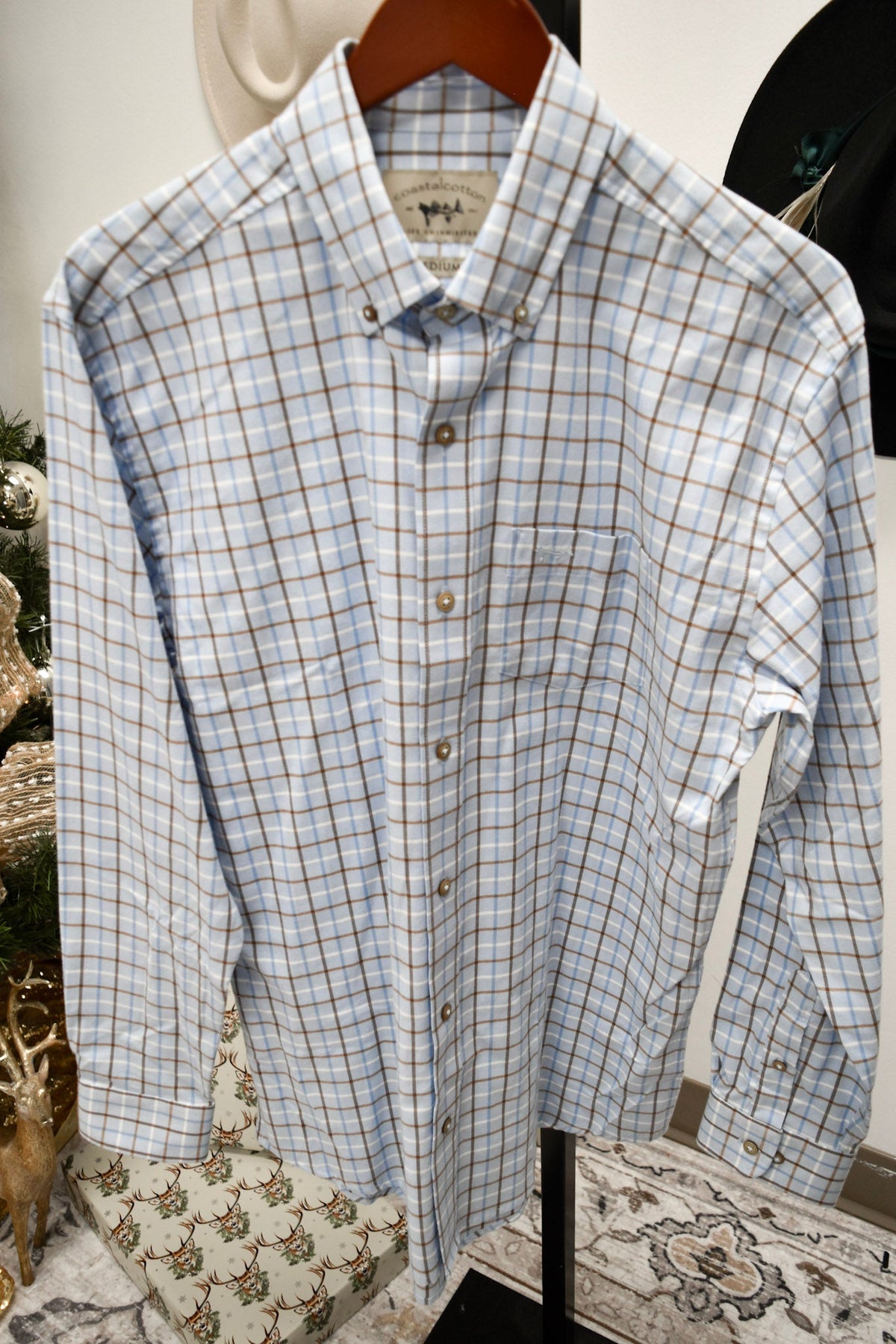 Coastal Cotton men's long sleeve button-down shirt in light bay blue plaid pattern on hanger