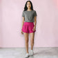 Grace in Motion Short in Berry Pink worn by model with gray tee and white sneakers