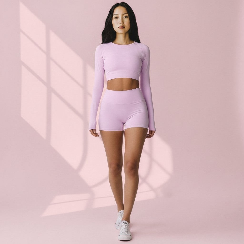 Mercifully Made Short in Light Rose, high-waisted athletic shorts worn with matching crop top and white sneakers