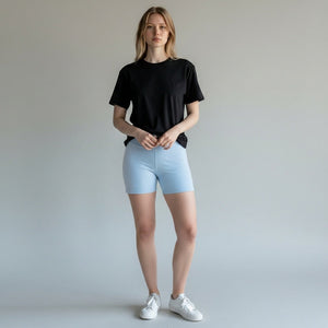 Mercifully Made Short in sky blue worn by model with black t-shirt and white sneakers