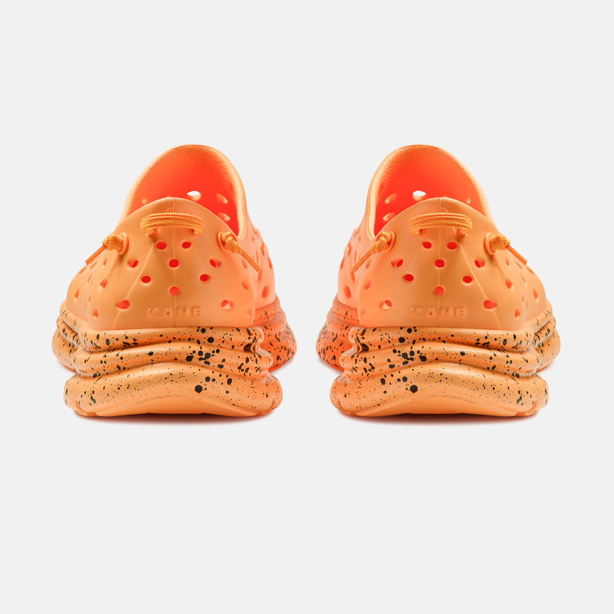 Kane Revive shoes in electric orange with black speckle chunky sole, rear view pair