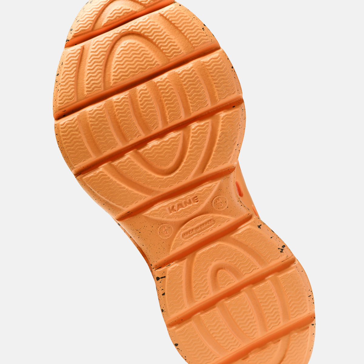Kane Revive shoe outsole in electric orange with black speckle detailing and wave tread pattern