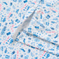 White polo shirt with blue and pink printed pattern of various icons and stars