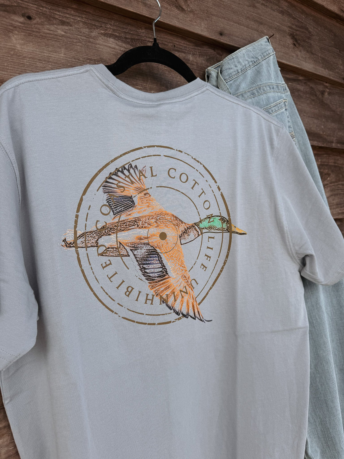 Coastal Cotton Mallard Tradewind Tee back view showing flying duck circular graphic on light blue-grey shirt