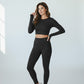 Woman wearing black long-sleeve crop top and matching black high-waist leggings activewear set