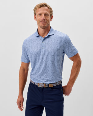 Light blue Johnnie-O Prawn Polo shirt with small white dot pattern worn by smiling man