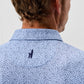 Back view of man wearing light blue polo shirt with navy paisley pattern