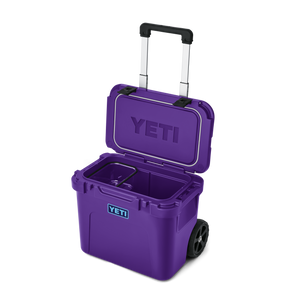 YETI Roadie 32 rolling cooler in Pace Purple with telescoping handle and wheels, open lid