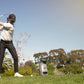 Golfer swinging club on course with Foresight QC3 launch monitor device placed nearby on grass